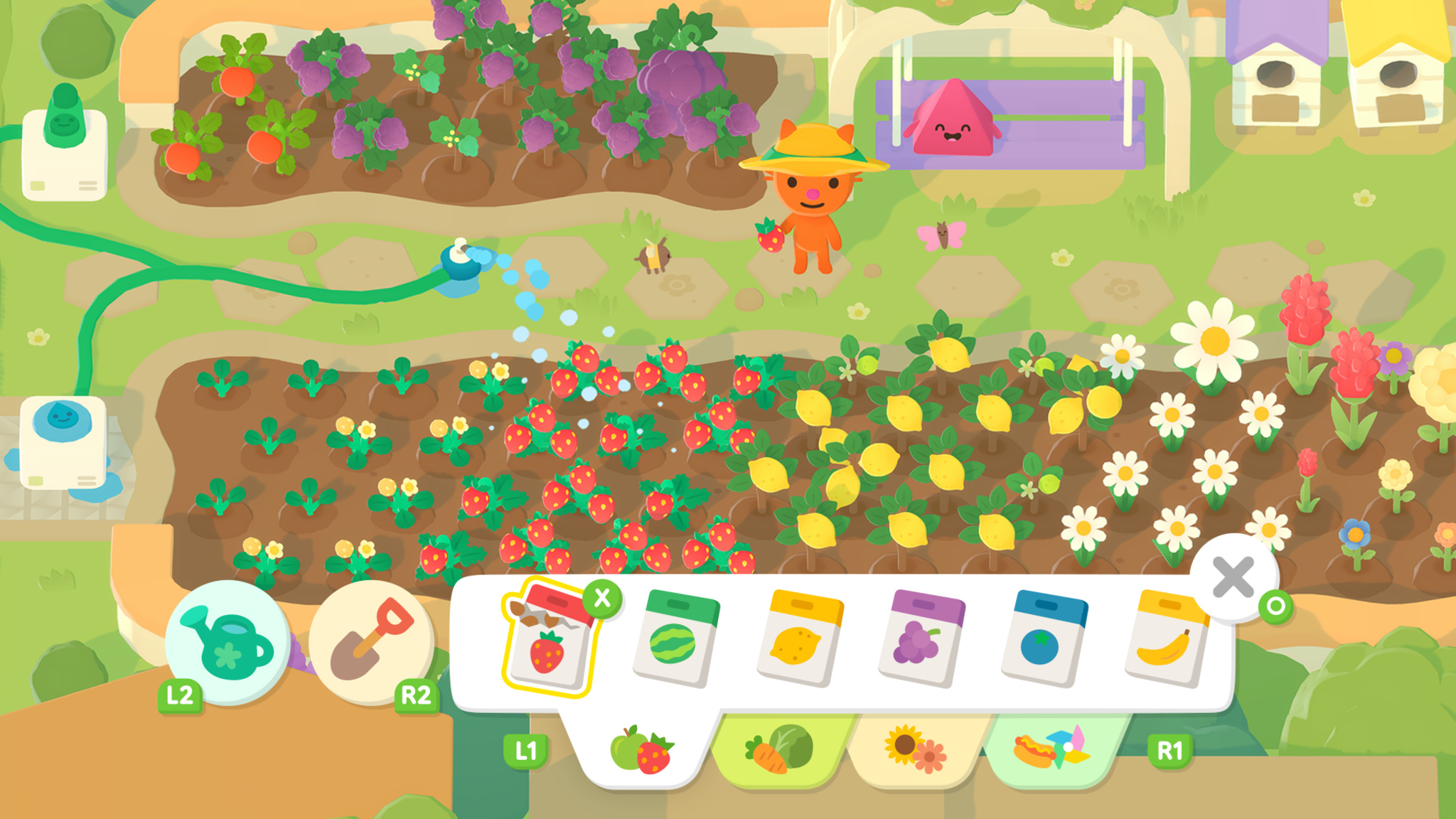 A top-down screenshot of a colorful farming game showing a small orange cat character in a yellow hat standing beside garden beds bursting with strawberries, lemons, grapes, and flowers. A sprinkler system waters the crops in the foreground while a happy pink triangle character watches from a fenced area in the background. A seed selection menu is open at the bottom of the screen, displaying packets for strawberries, watermelon, lemon, grapes, and more, with controller button prompts visible.