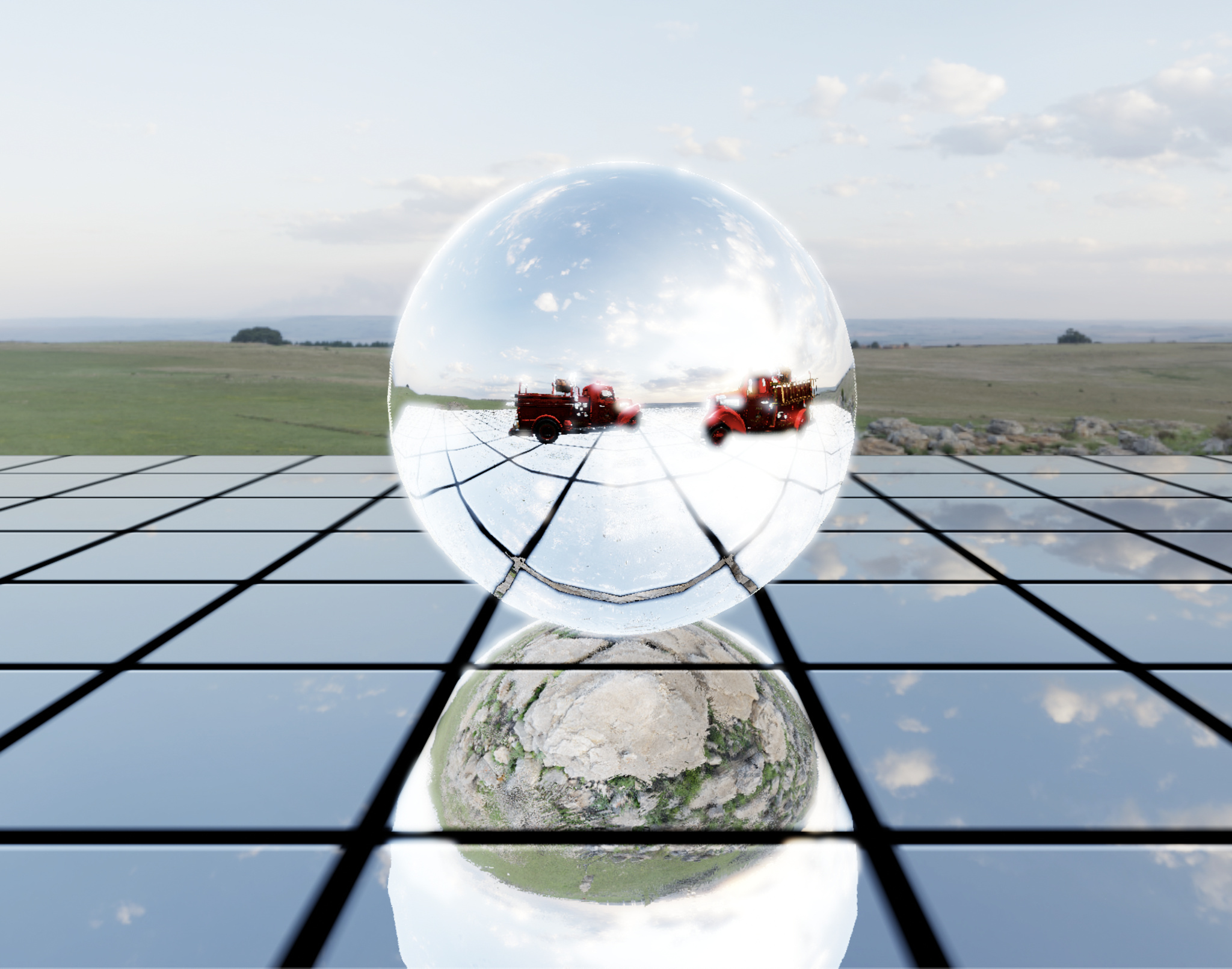 An artistic image of a mirrored sphere reflecting on a mirrored surface in an outdoor setting. The sphere contains images of two red fire trucks, which are not reflected on the mirrored surface beneath.