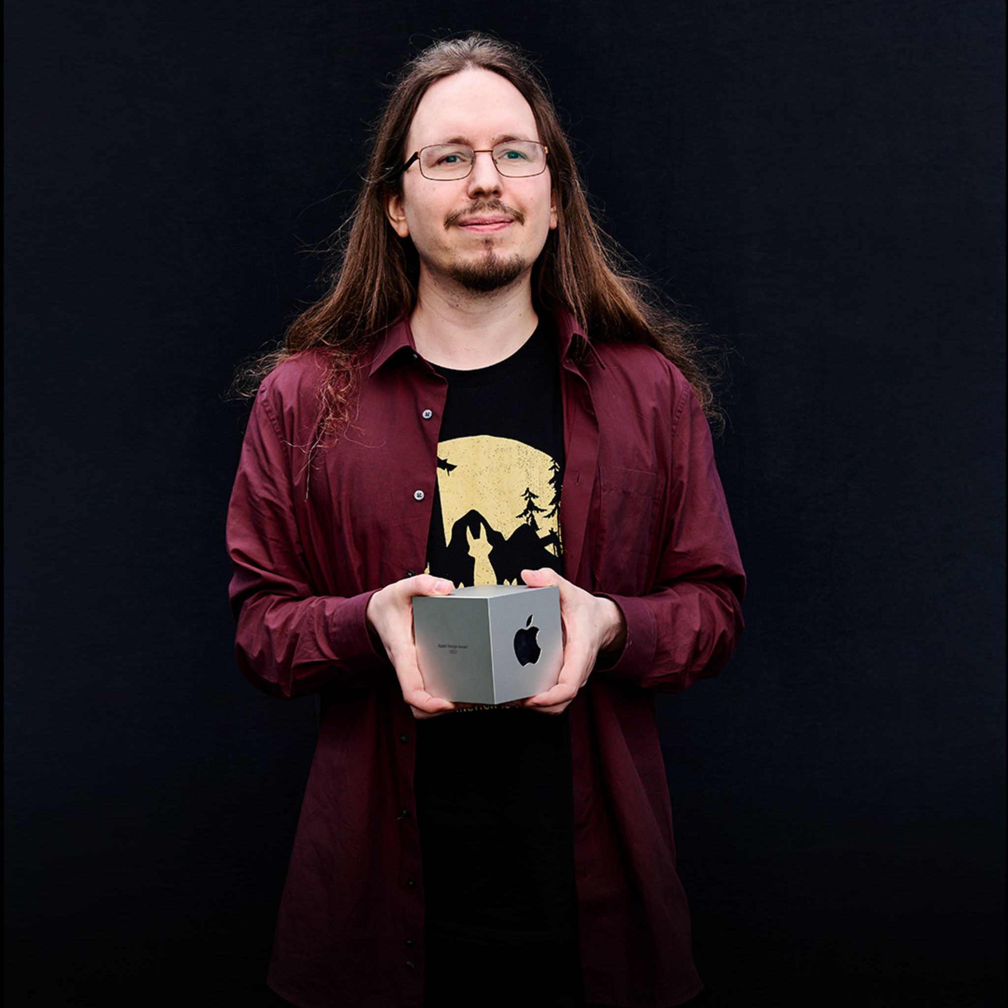 A portrait of Philipp Nägelsbach of the HandyGames studio, holding his Apple Design Award.