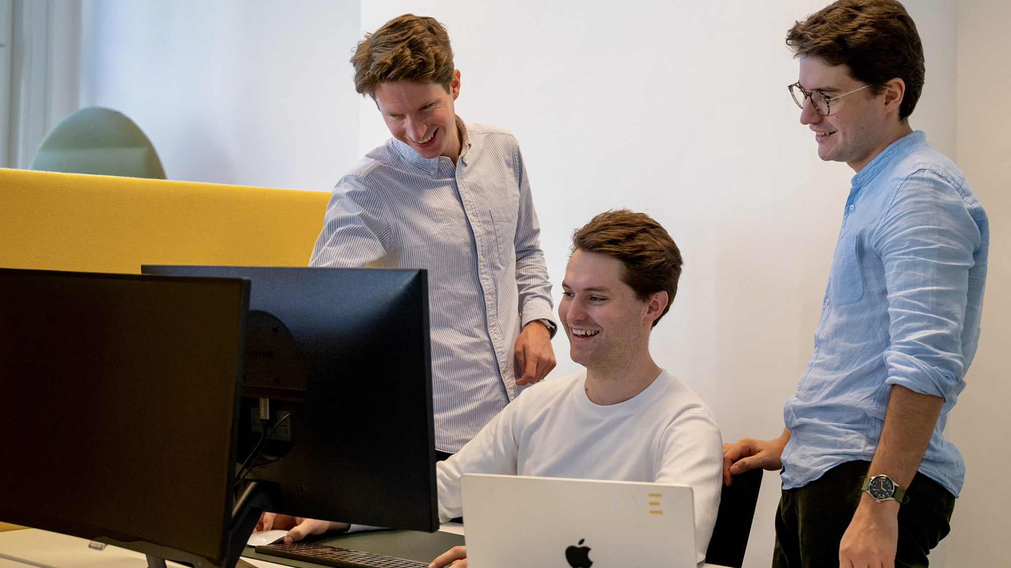 Oko’s three cofounders, Vincent Janssen, Michiel Janssen, and Willem Van de Mierop, gather around a bank of monitors to review their app.