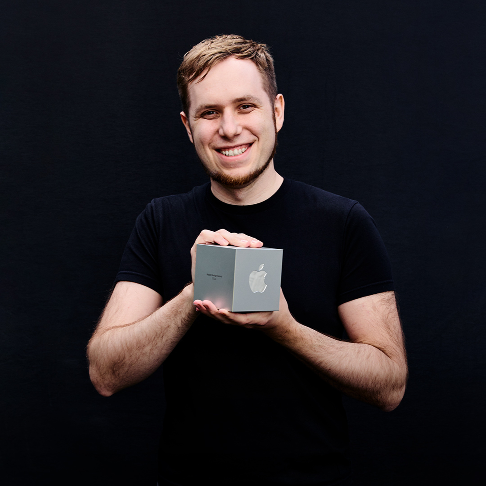 A portrait of Luke Spierewka of the Afterburn studio, holding his Apple Design Award.