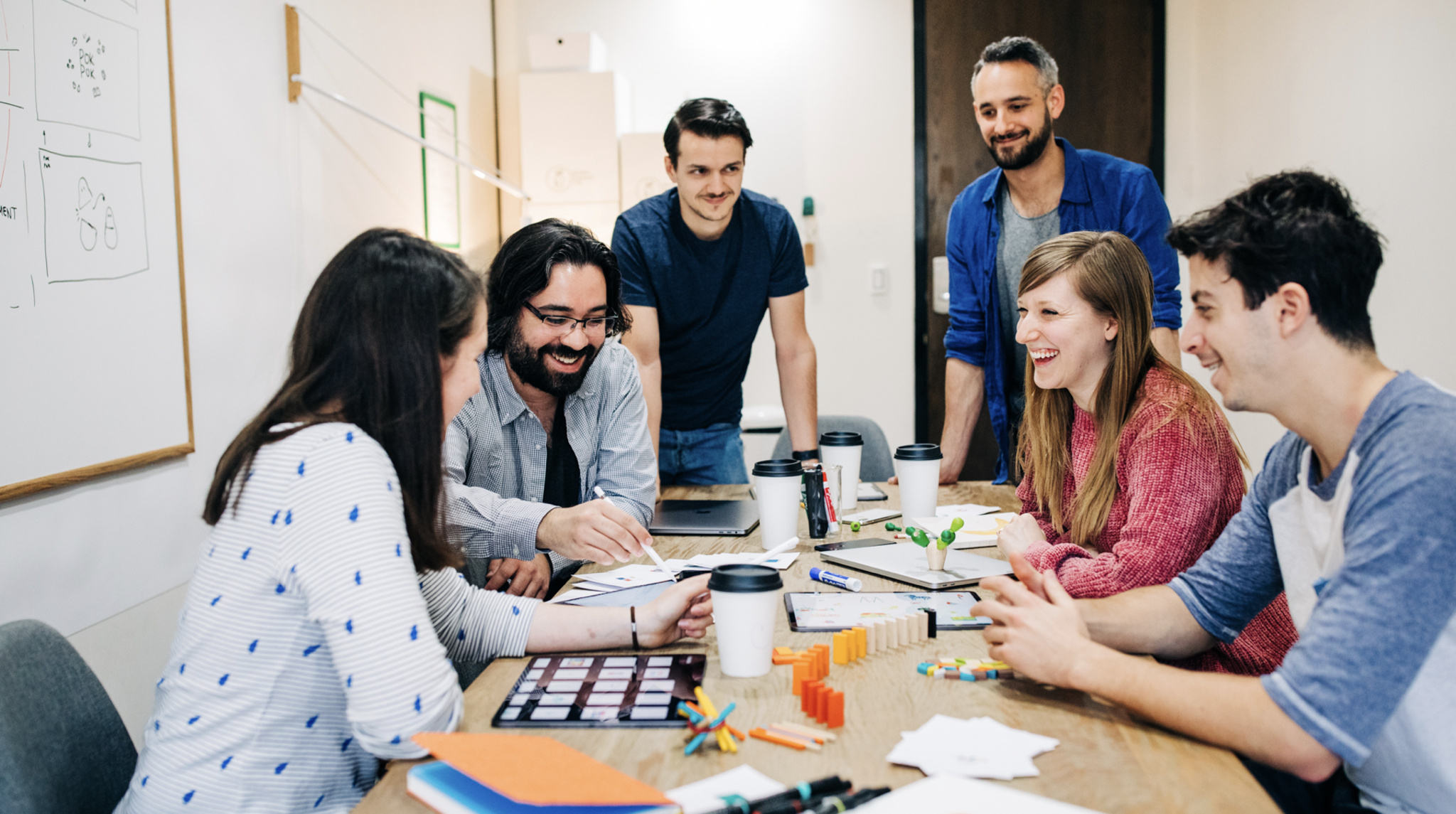 The team behind Pok Pok Playroom sits at a conference room testing toys.