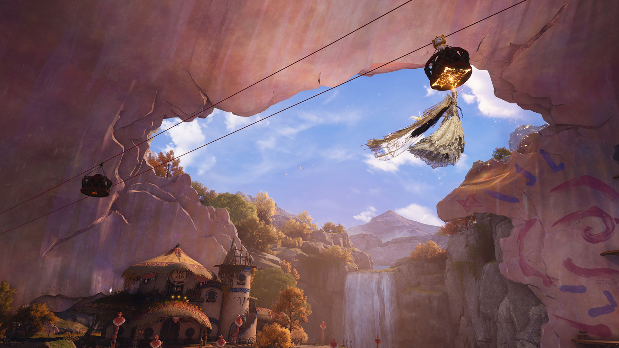 Viewed from inside a cave opening, a fantasy game character in a white gown hangs from a zipline cable, soaring above a colorful village nestled among rocky cliffs and autumn-colored trees, with a waterfall in the background.