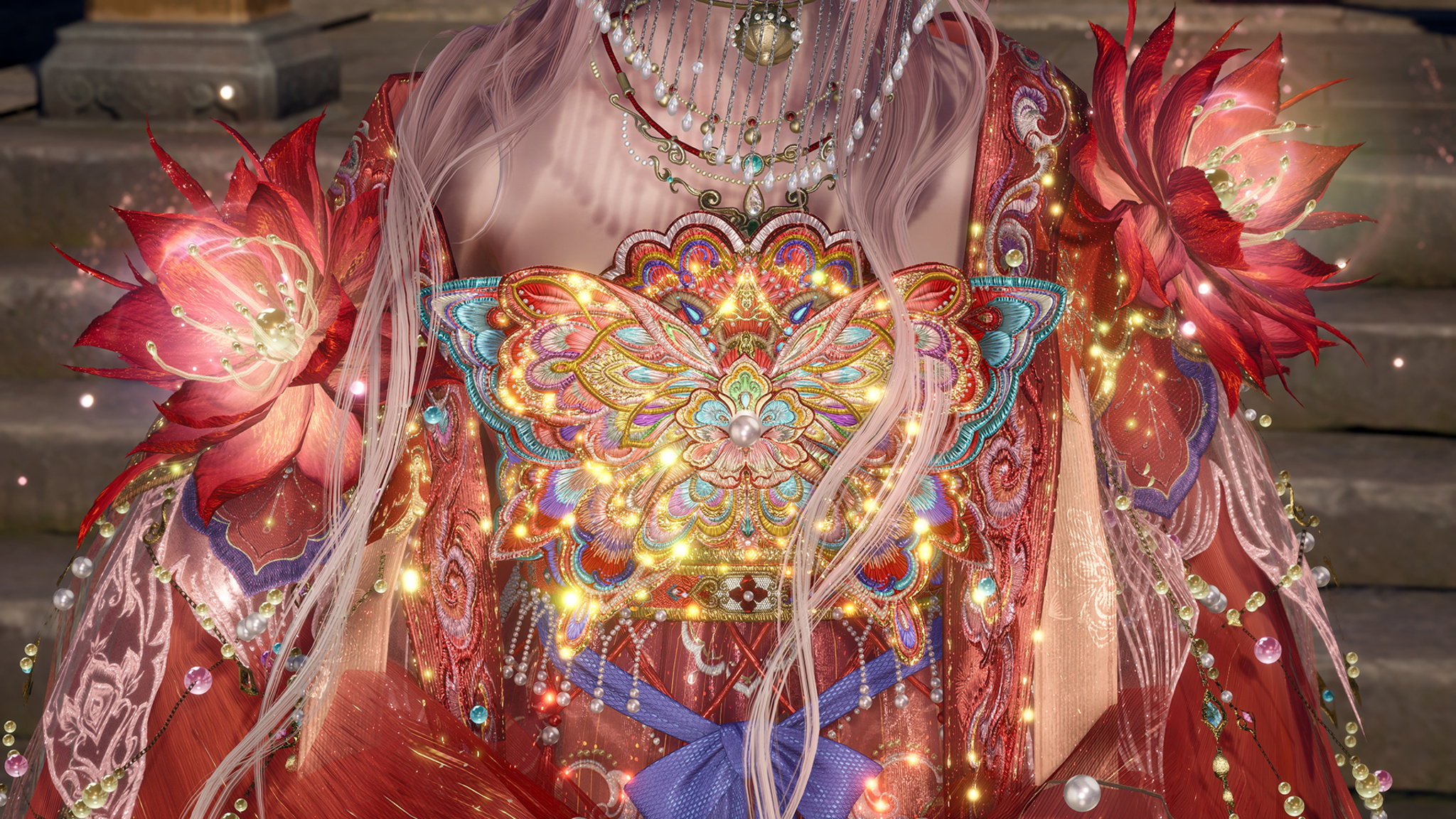 A close-up of a highly ornate red and gold garment featuring a brightly colored, embroidered butterfly design on the chest, accented with glowing lights, draped pearls, and large red lotus flowers on the shoulders.