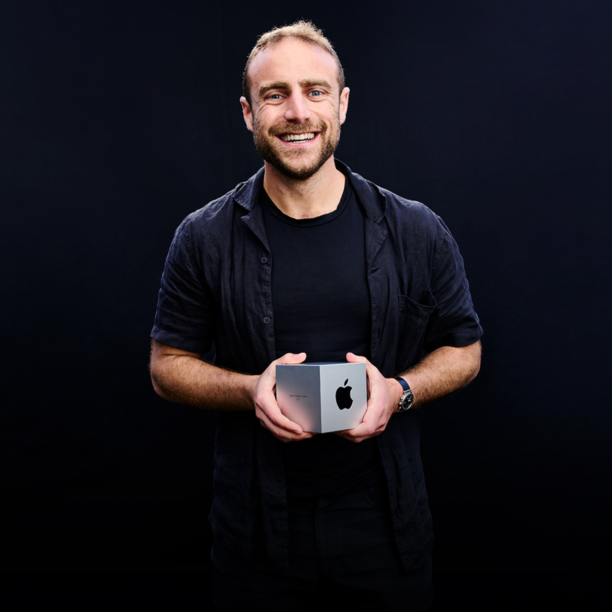 A portrait of Joseph Cohen, Universe founder, holding his Apple Design Award.